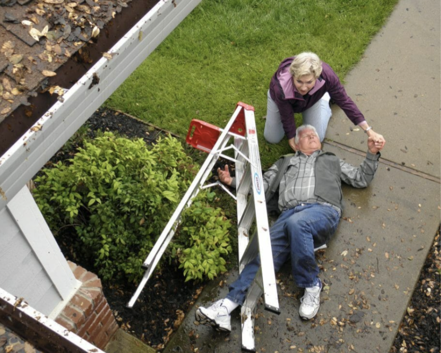 A man is laying on the ground while a woman looks on