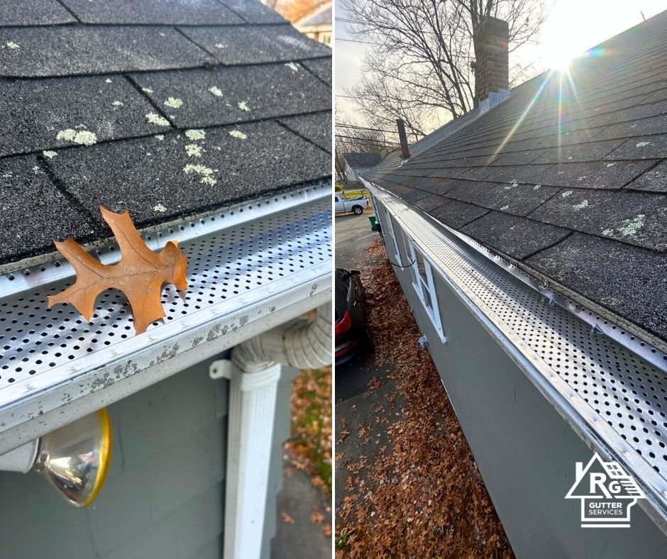 A leaf is hanging from a gutter next to a roof.