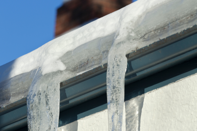 Icicles are hanging from the side of a building