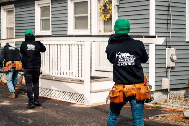 A group of construction workers are working on a house.