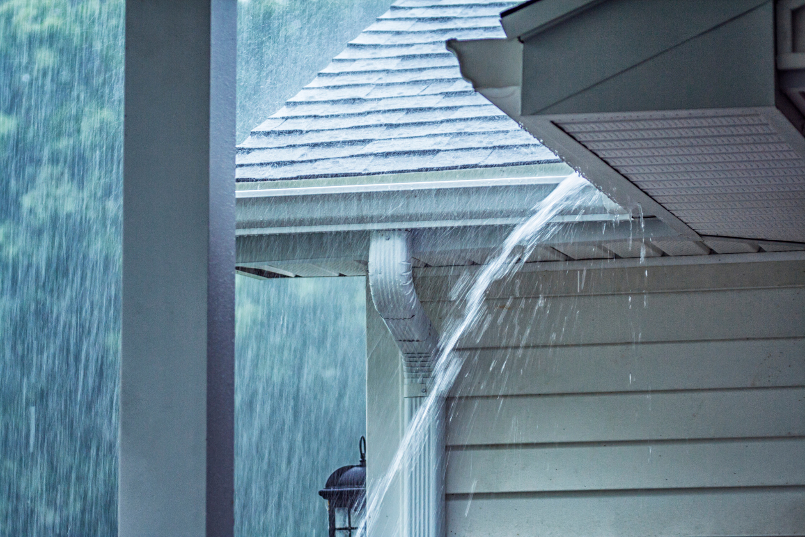 Rain is falling from the roof of a house.