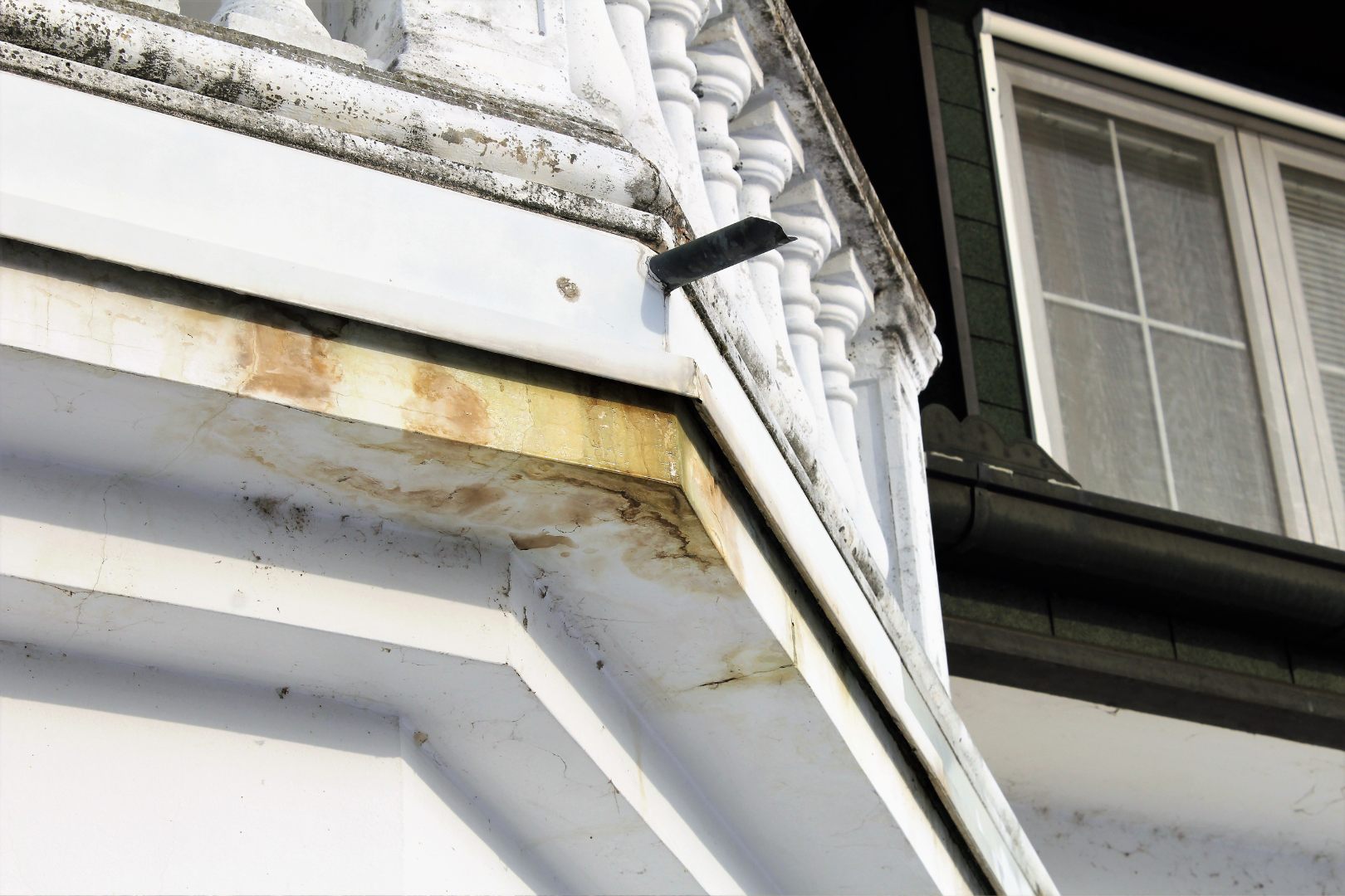 A close up of a gutter on the side of a building