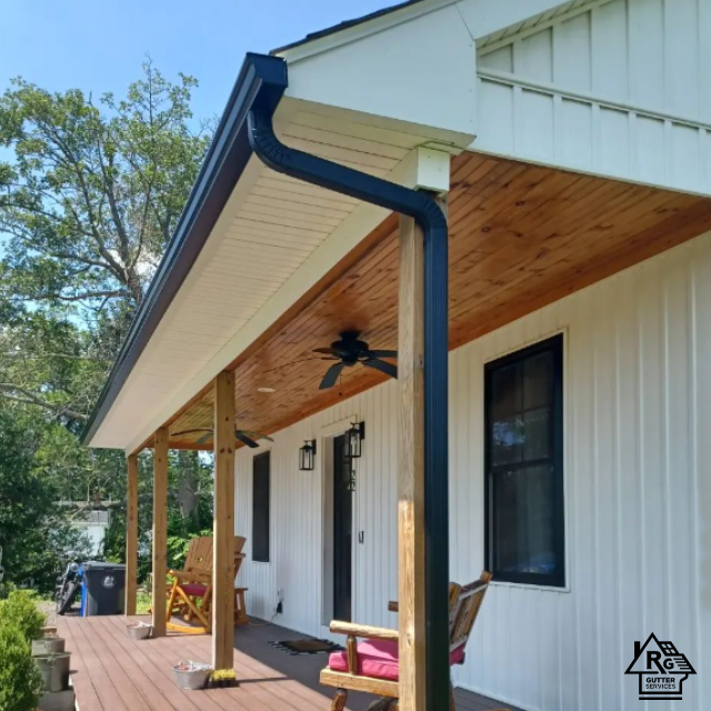 A white house with a black gutter and a ceiling fan