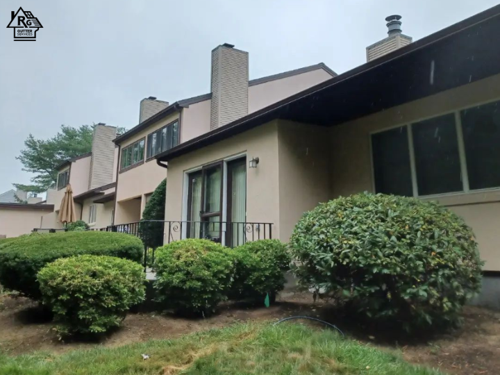 A house with a lot of windows and bushes in front of it