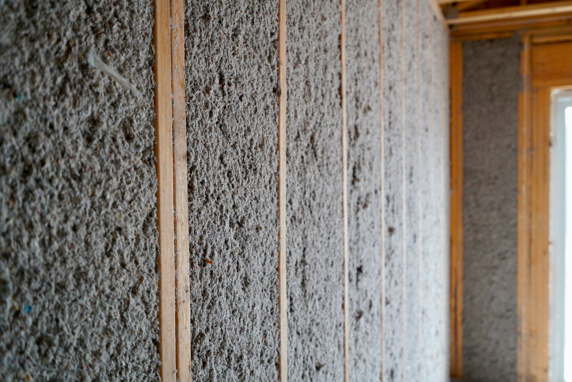 A man wearing a hard hat and goggles is standing in a room.