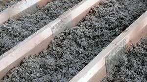 Two men are standing in an empty room with black walls