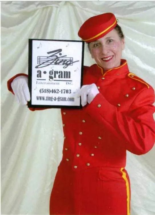 Woman in red uniform holding a sign for “Bongo a gram” against a white backdrop.