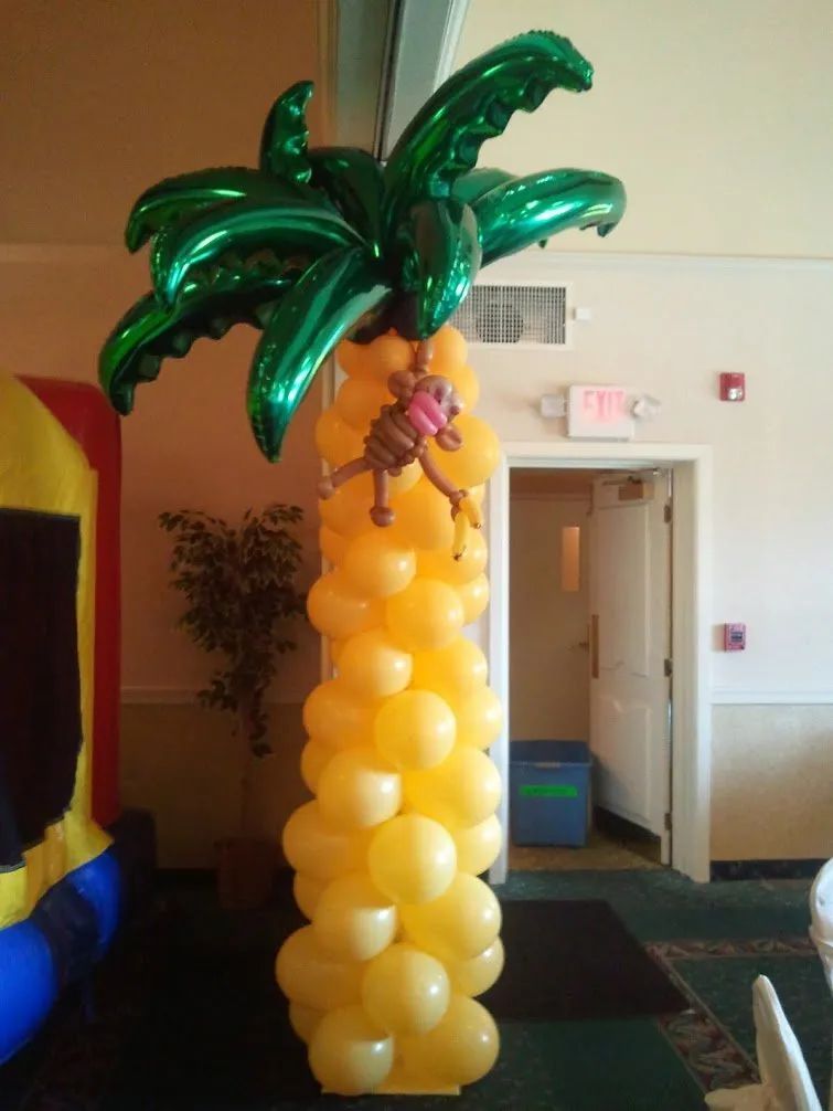 Yellow balloon palm tree sculpture with green leaves in an indoor room