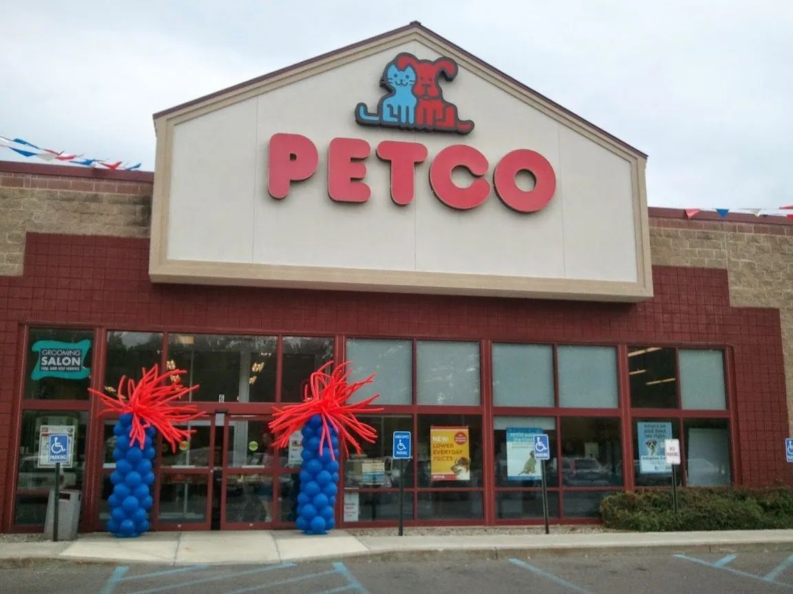 Petco storefront with red sign, brick facade, and blue balloon columns by the entrance