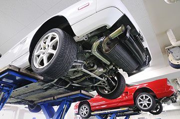 A car is being aligned on a lift in a garage.