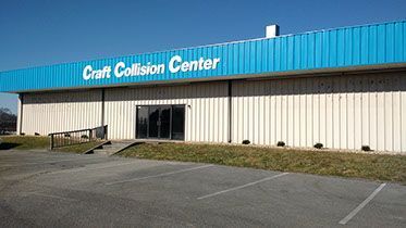 A white building with a blue roof and the words craft collision center on it.