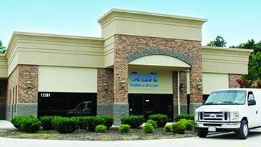 A white van is parked in front of a building.