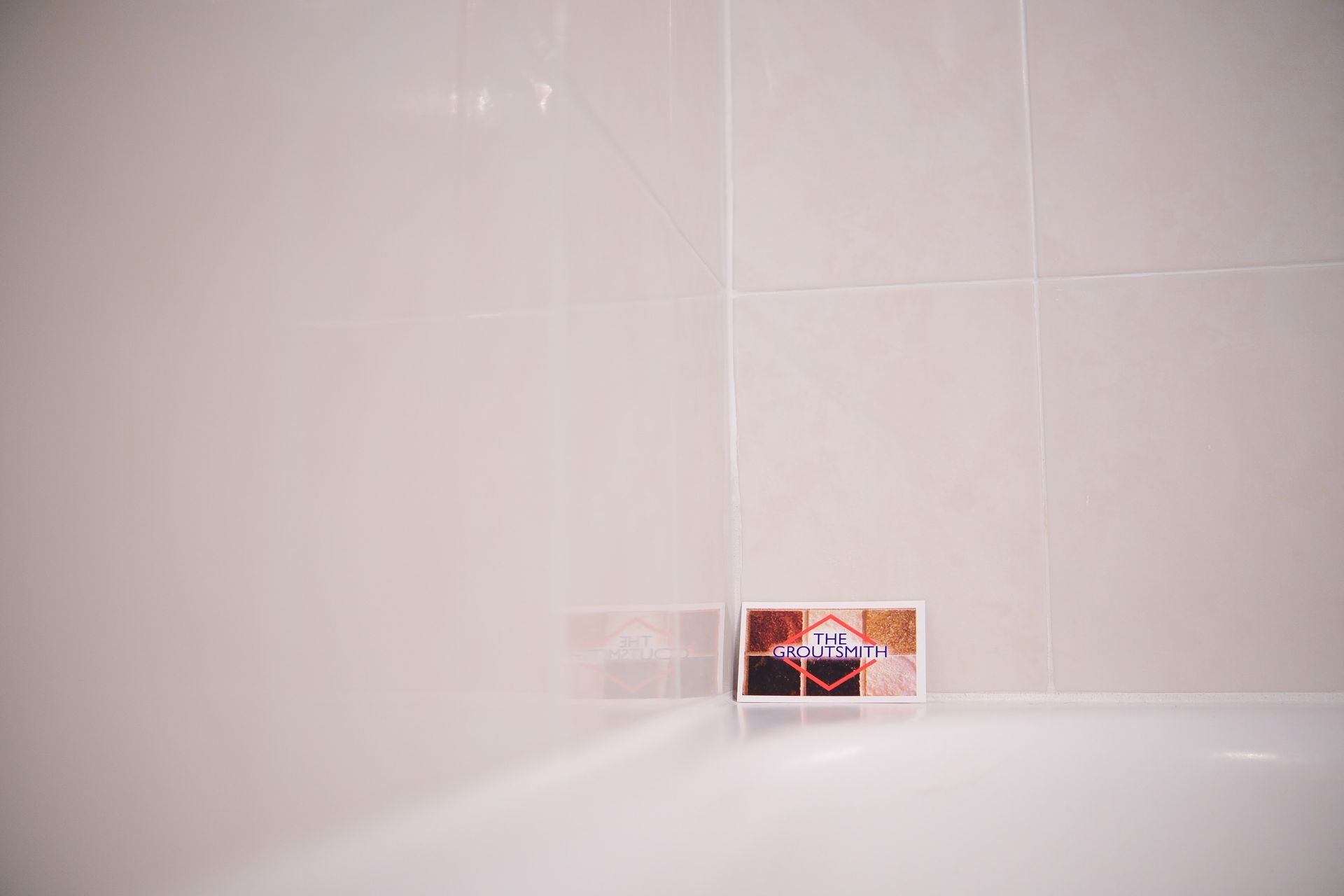 White tiled wall with a soap dish in the center.