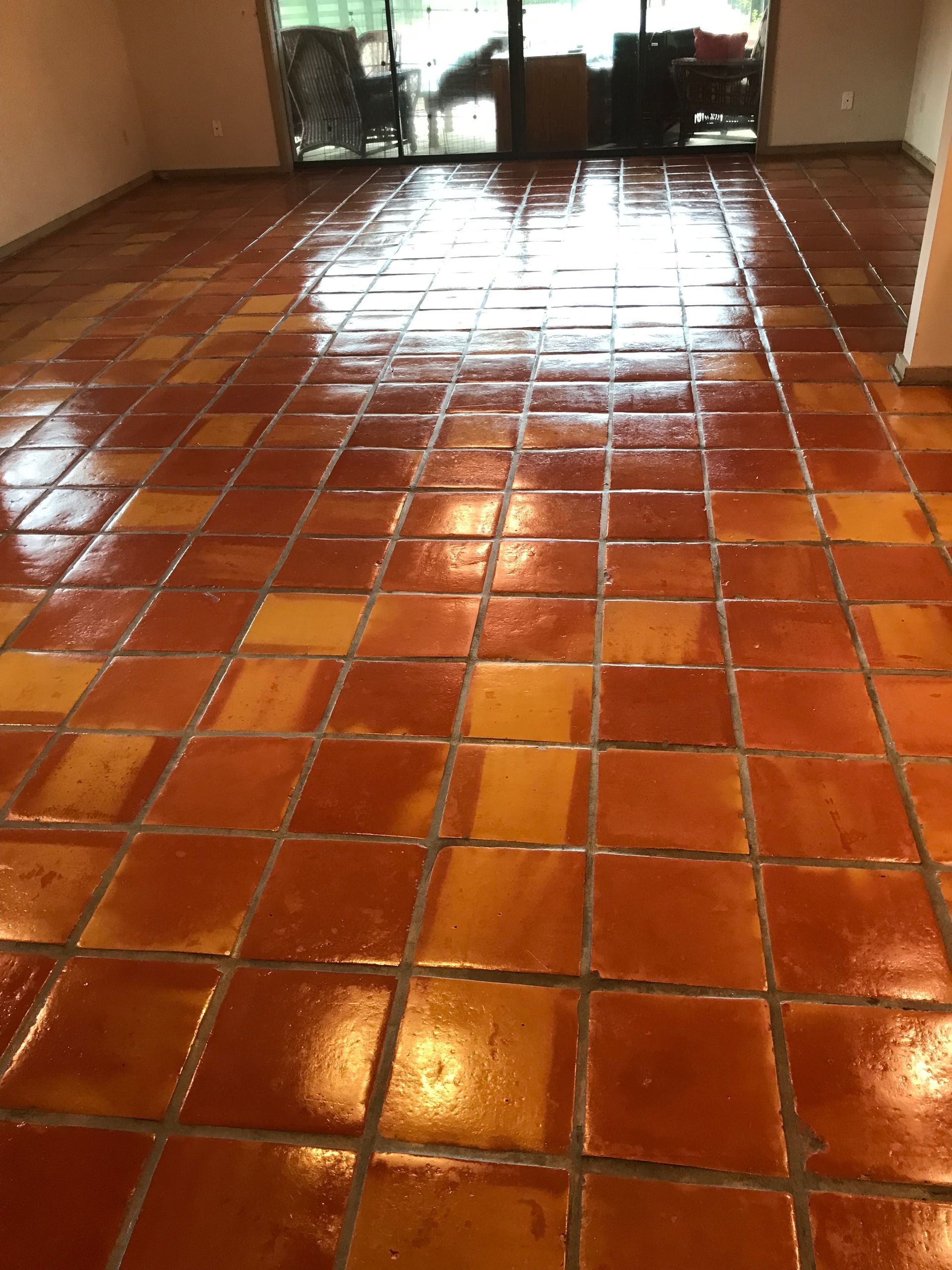 Mop on a tiled floor next to a blue bucket. The mop is wet and cleaning.