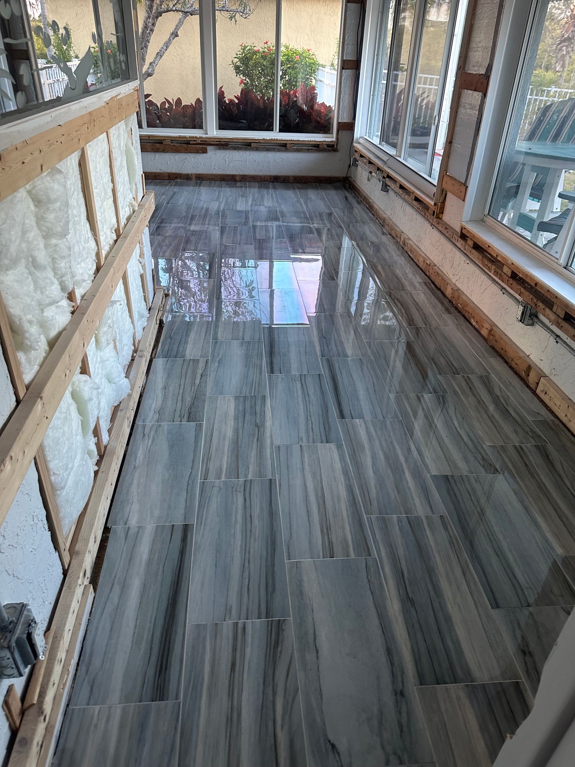 A modern, minimalist bathroom with a glass shower, white toilet, and sink against a white wall.