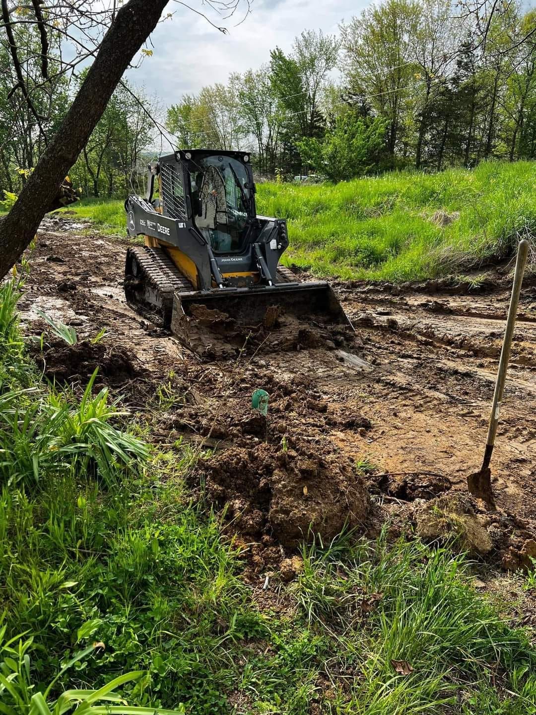 a bulldozer is driving through a muddy field .