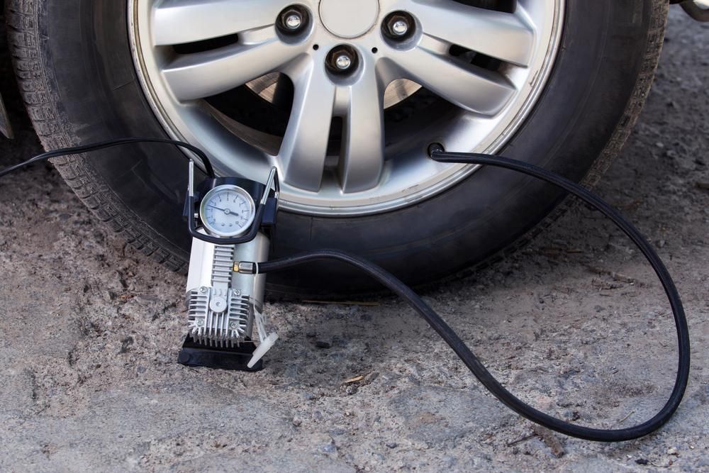 A Car Tire Is Being Inflated with An Air Pump — Petersen's Second Hand & New Tyres in Currajong, QLD
