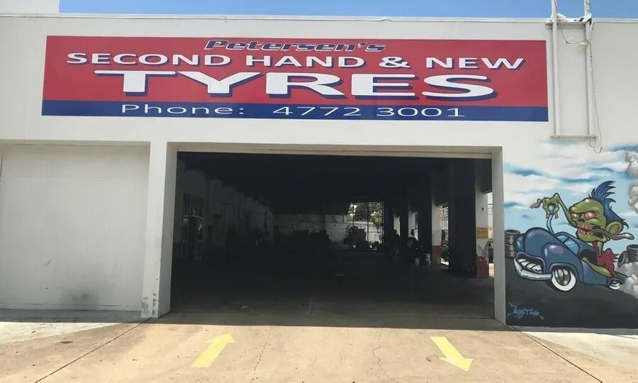 A Building with A Sign that Says Second Hand and New Tyres — Petersen's Second Hand & New Tyres in Currajong, QLD