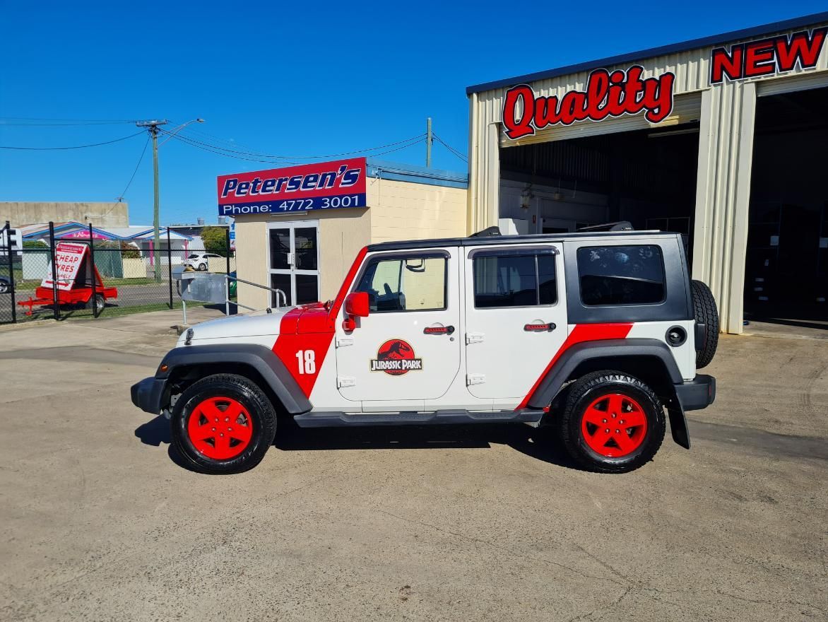 A White and Red Jeep Is Parked in Front of A Quality New Tire Shop — Petersen's Second Hand & New Tyres in Currajong, QLD