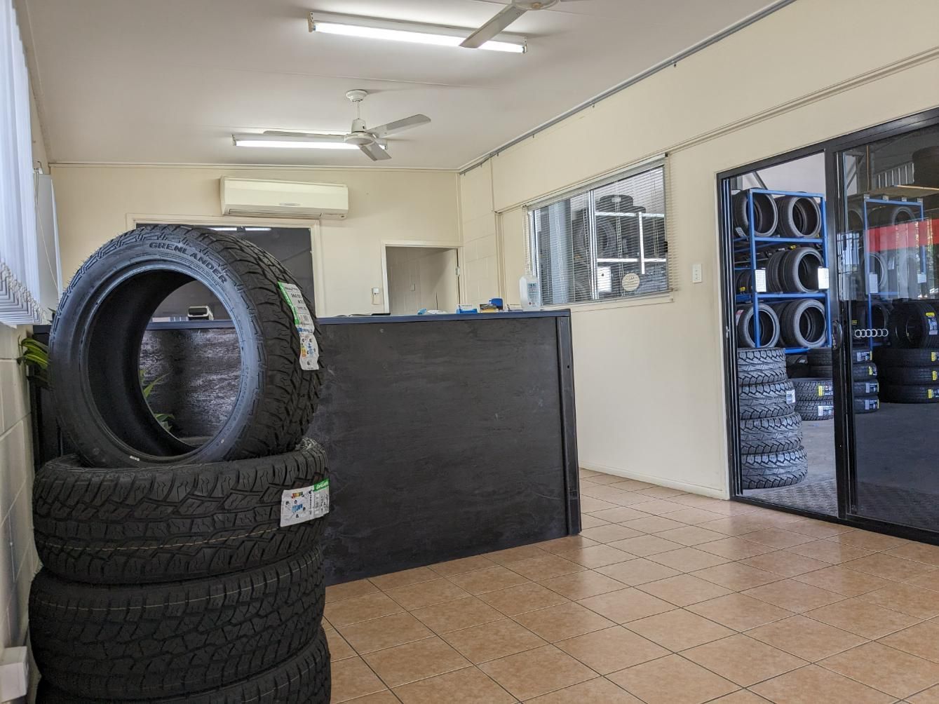 A Stack of Tires Is Sitting on Top of A Counter in A Room — Petersen's Second Hand & New Tyres in Currajong, QLD