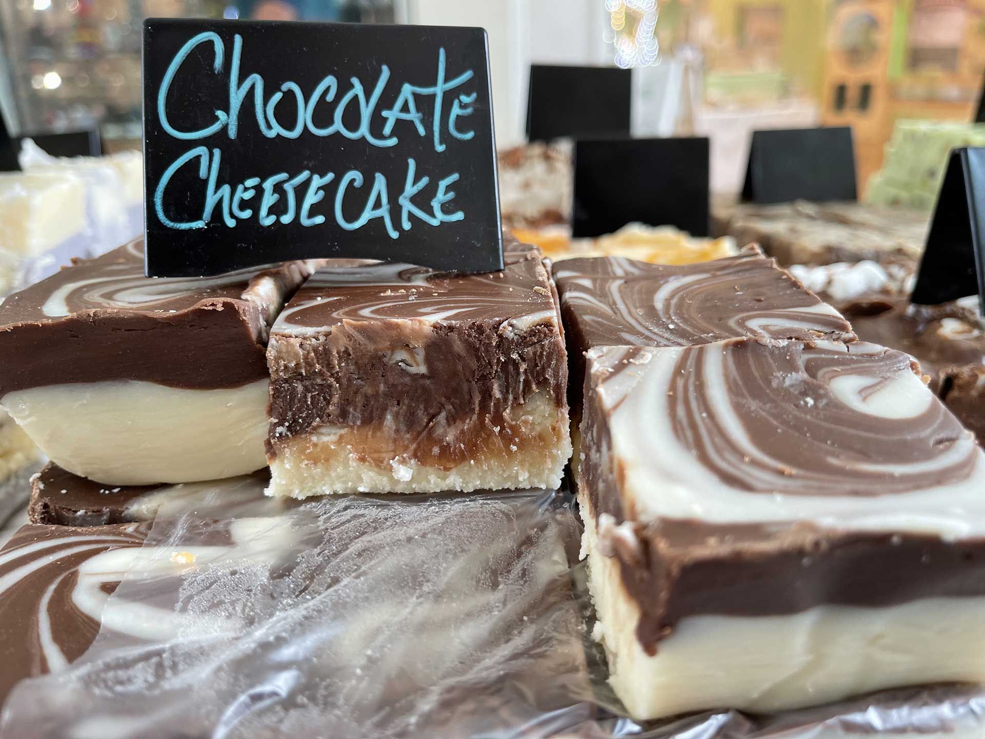 Chocolate cheesecake fudge with a swirl of chocolate and white, displayed in a shop.