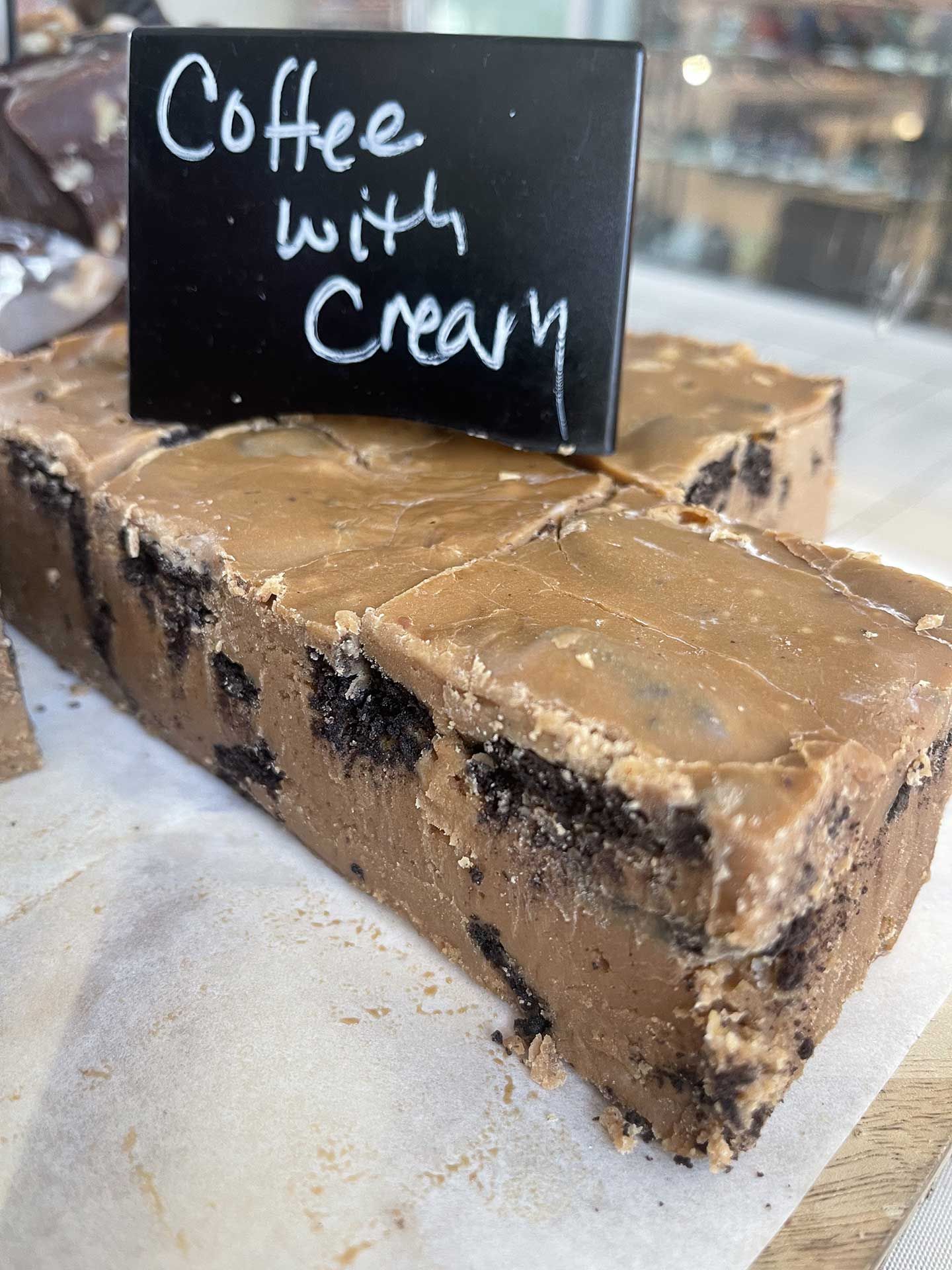 Coffee with cream fudge on a white surface, with a black label.
