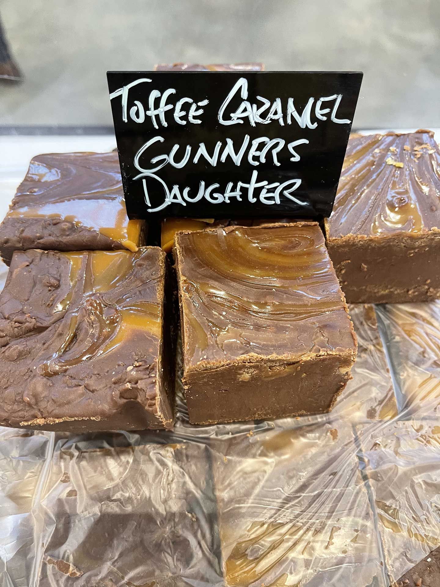 Squares of toffee caramel fudge, swirled with caramel, with a sign reading
