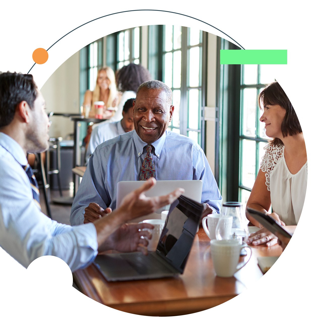 Three colleagues smiling around a table, working together in an office.