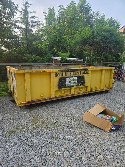 Yellow dumpster on gravel, 