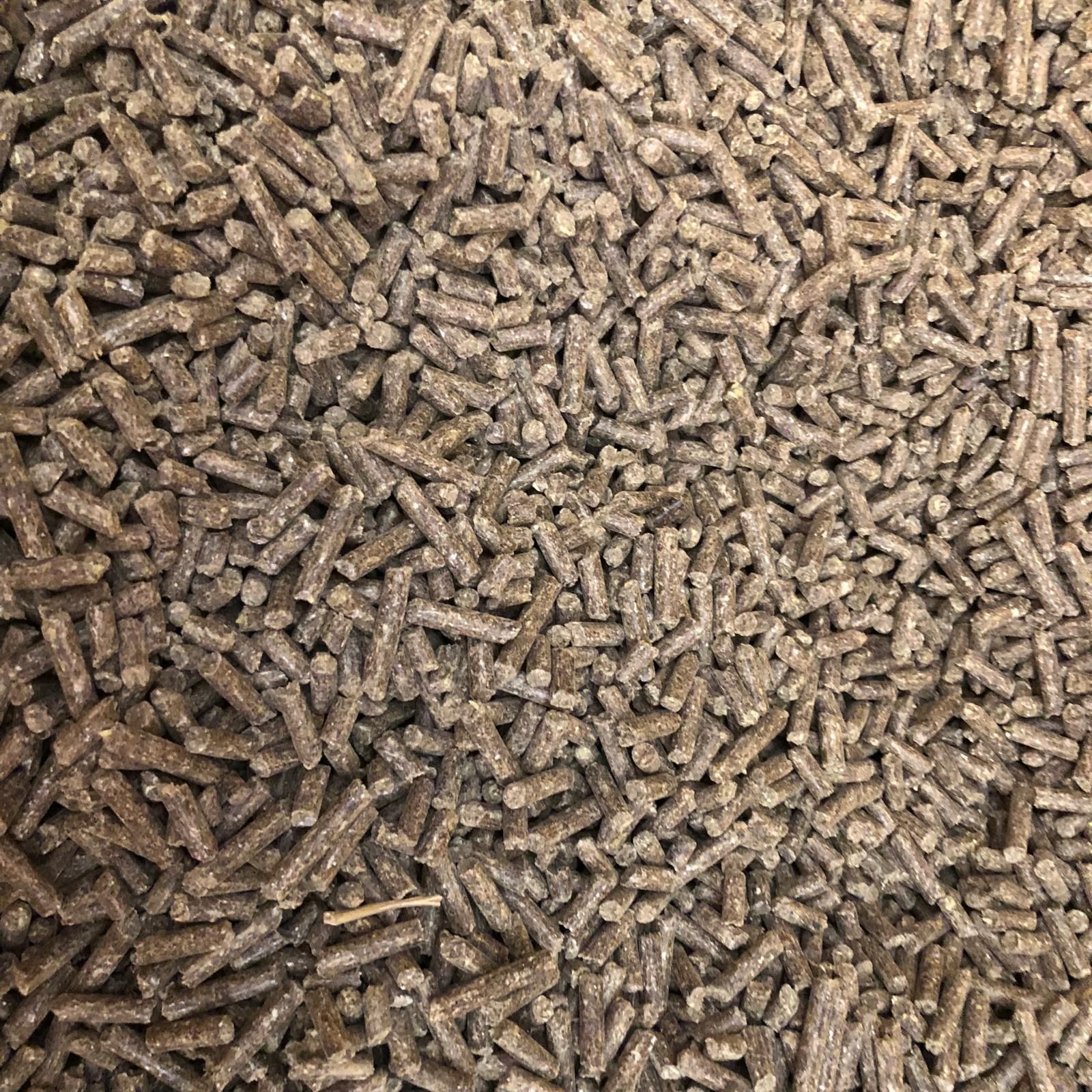 Nahaufnahme eines Haufens kleiner, brauner Pellets mit Mineralstoffen und Spurenelementen; Primer plano de un montón de pellets marrones pequeños con minerales y oligoelementos