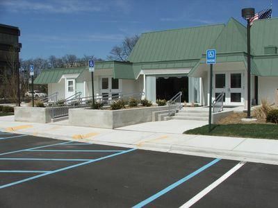 Small building with a green roof and accessible parking spaces in front