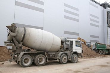 a concrete mix vehicle standing near a construction site