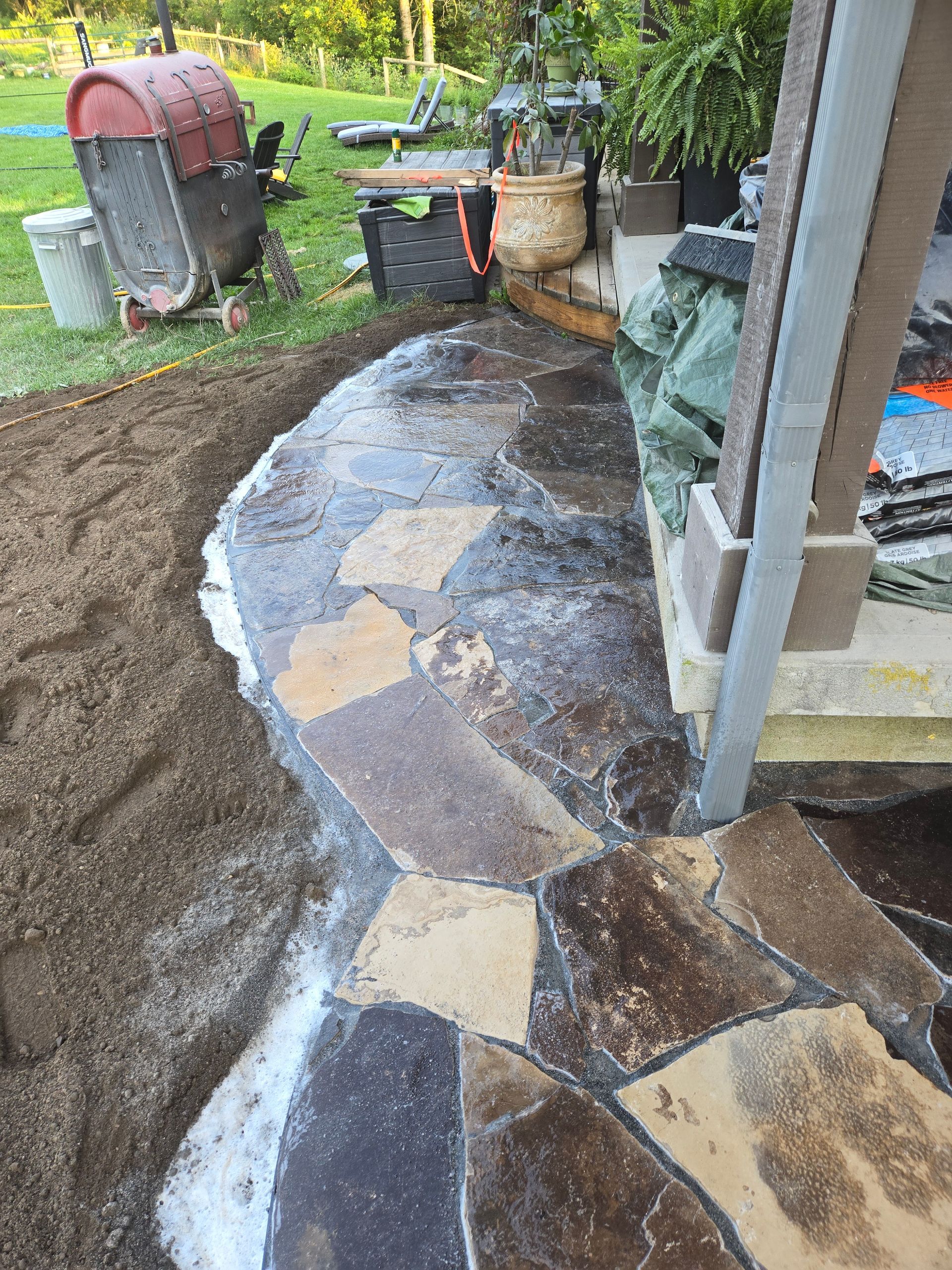 A stone walkway is being built in a backyard.