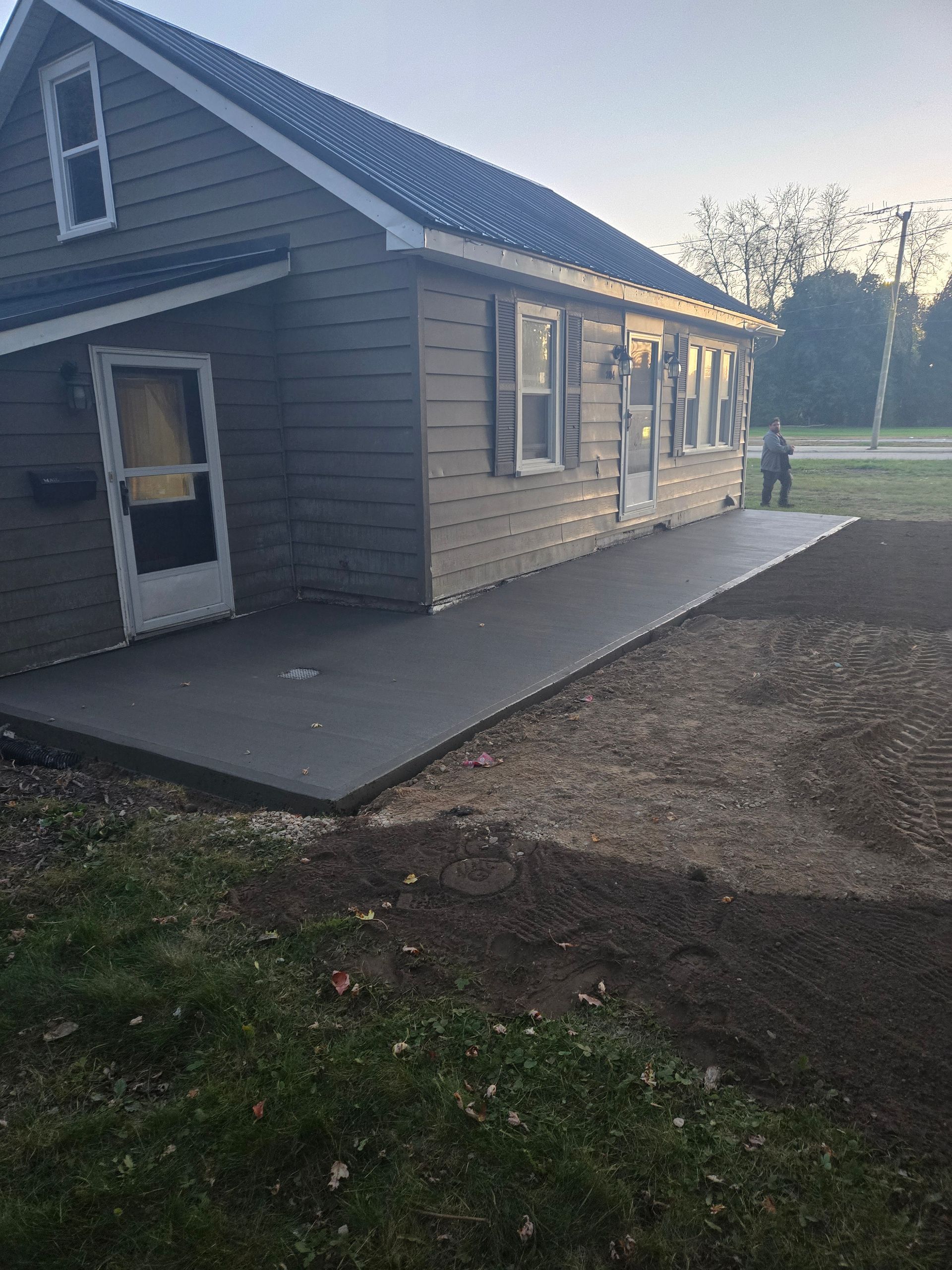 A house with a concrete walkway in front of it.