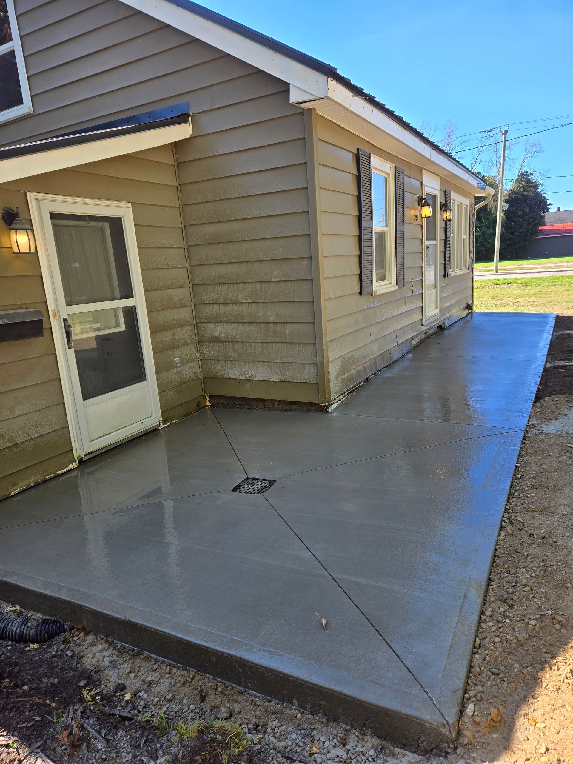 A house with a concrete patio in front of it.