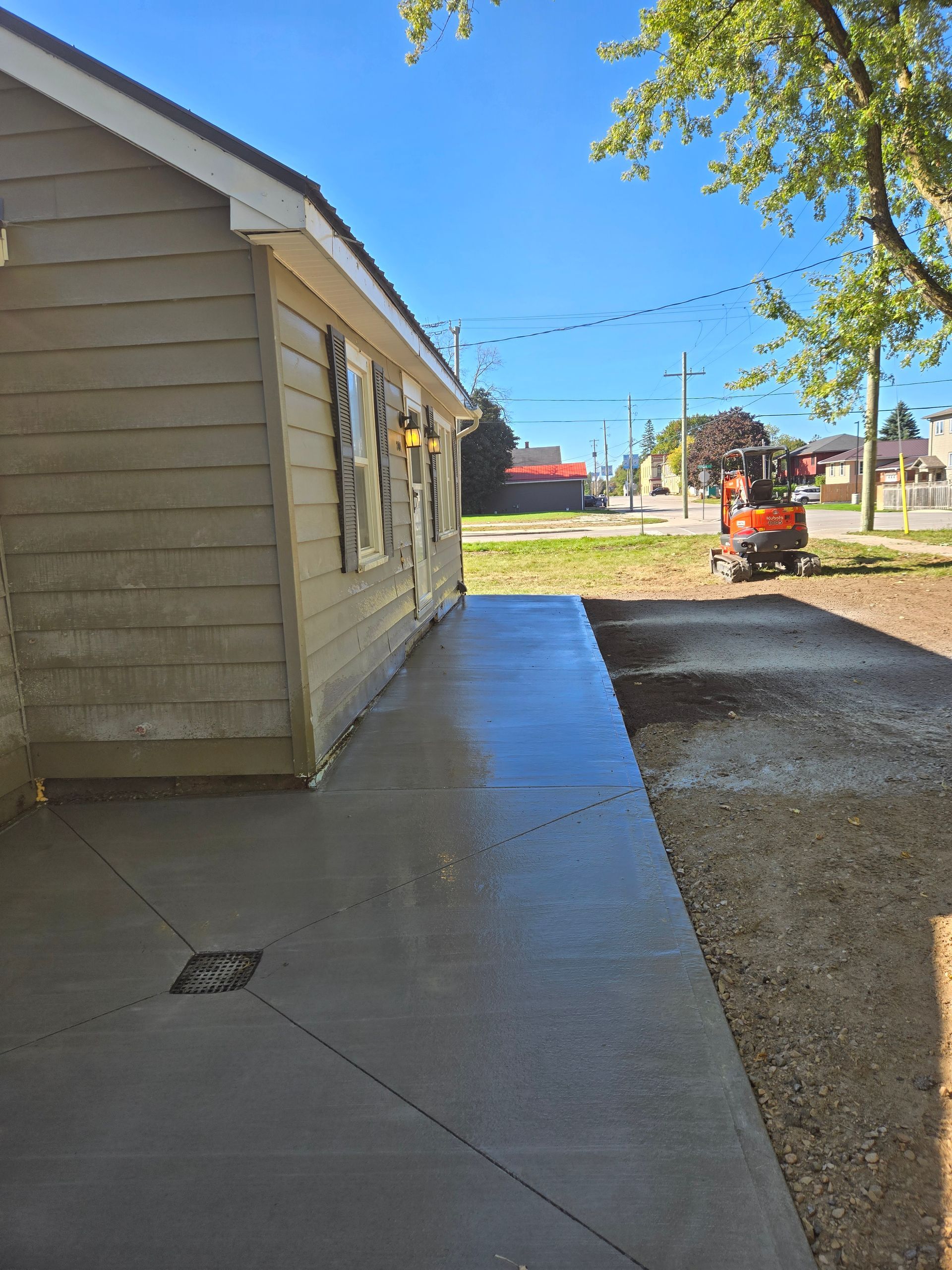 A concrete walkway is being built in front of a house.