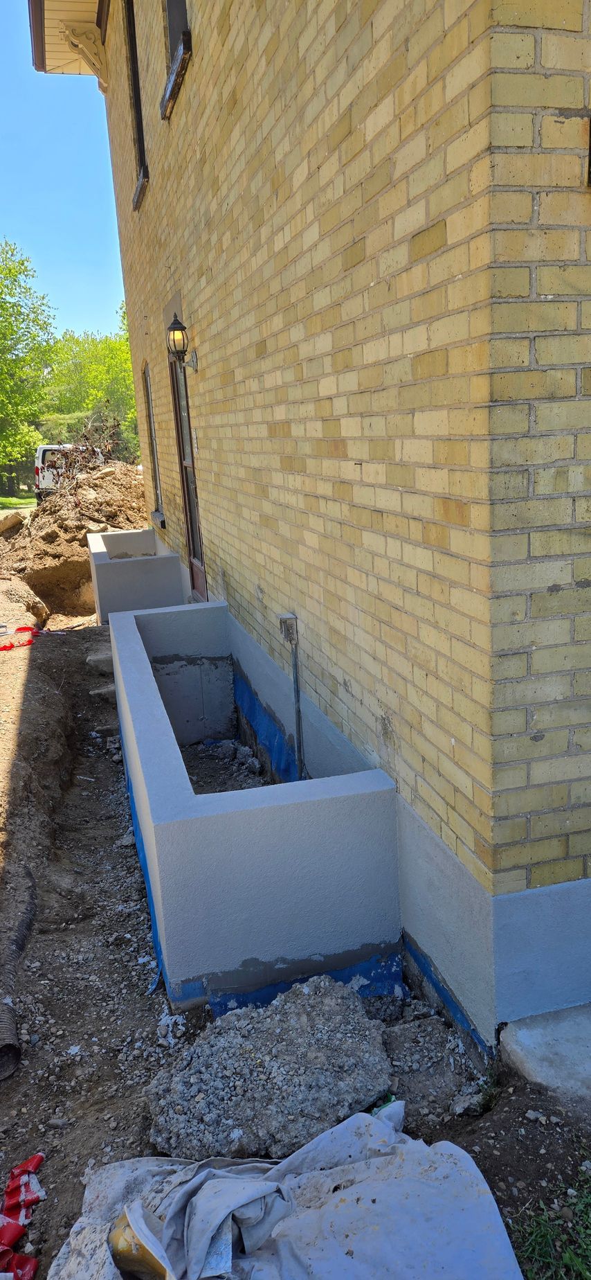 A brick building with a concrete planter on the side of it.