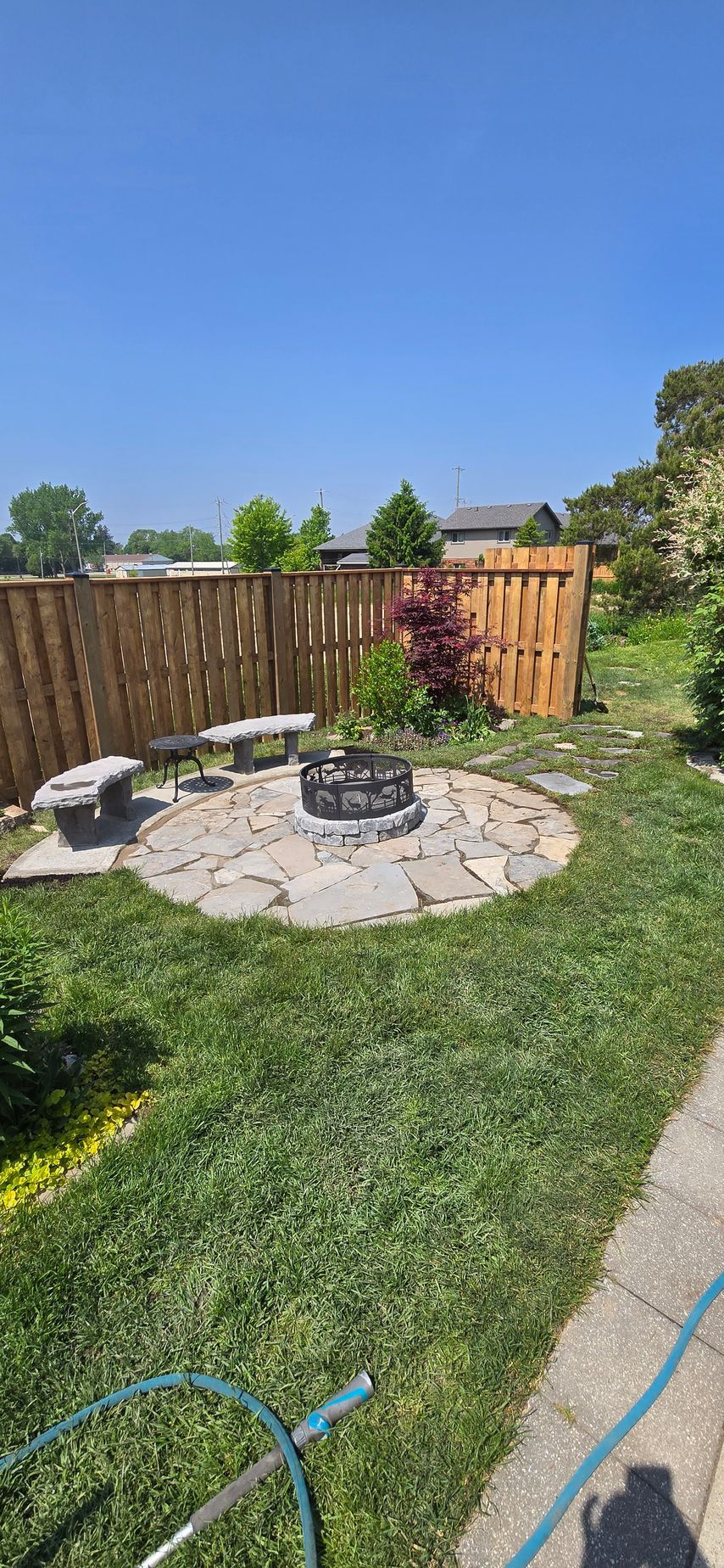 There is a fire pit in the middle of the backyard.