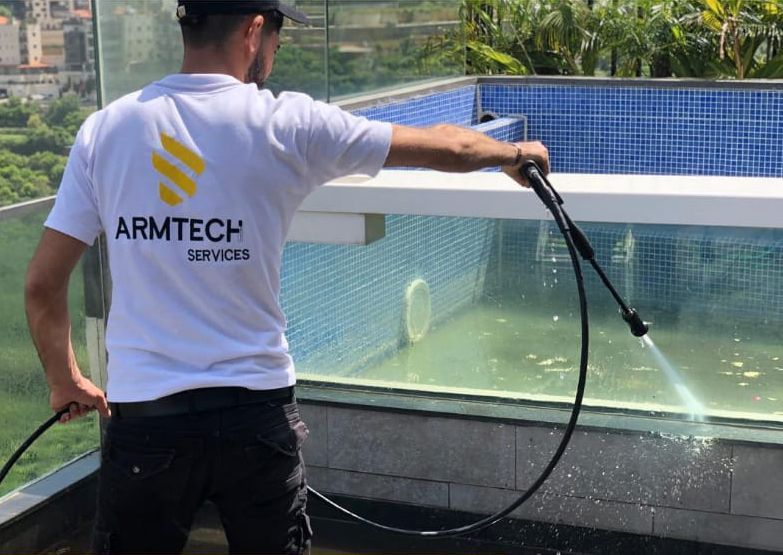 A cleaner is cleaning a swimming pool