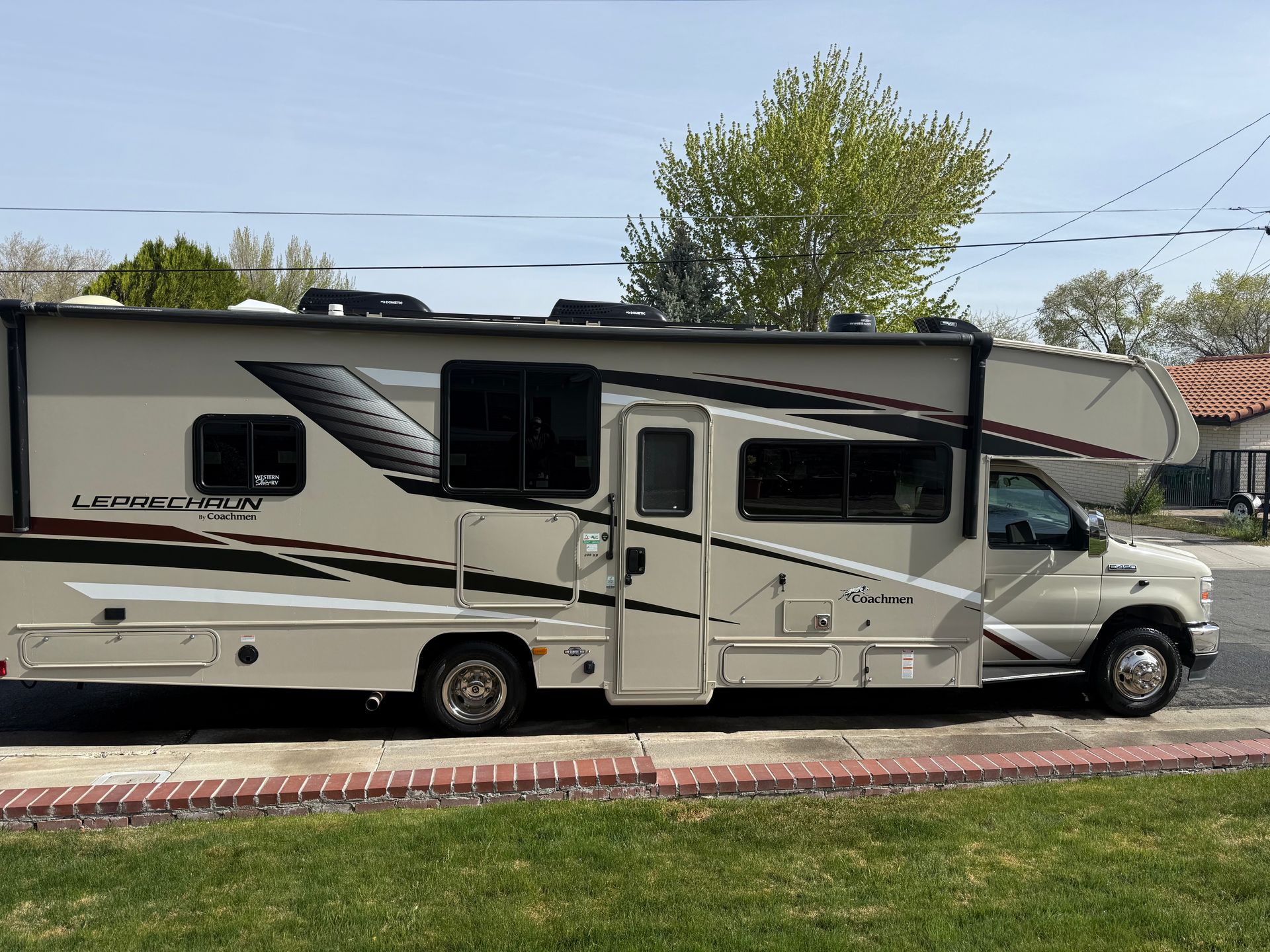 A white rv is parked on the side of the road.