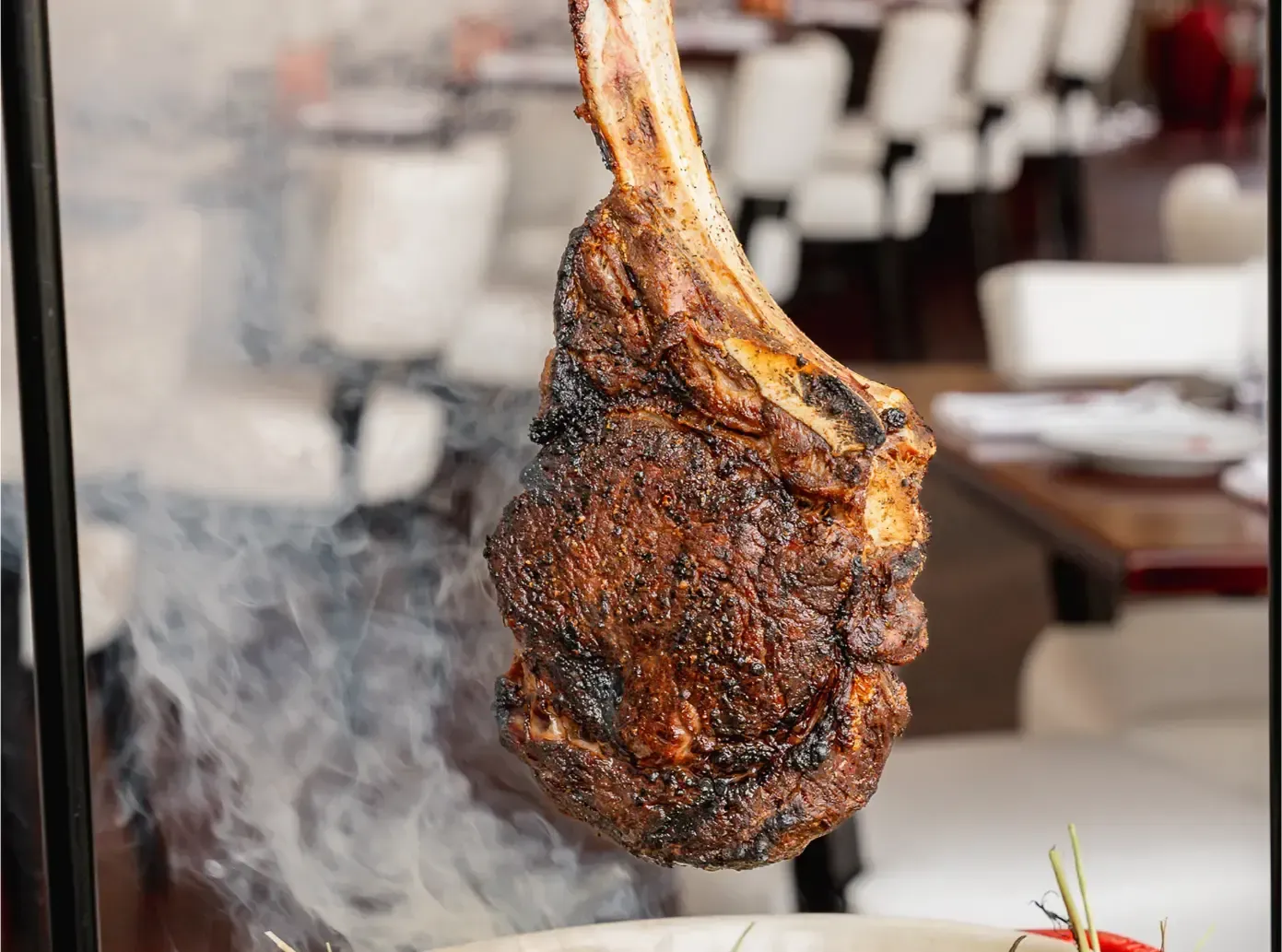 Two people stretch legs on massage tables under a canopy, one assisting the other. Green grass outdoors.