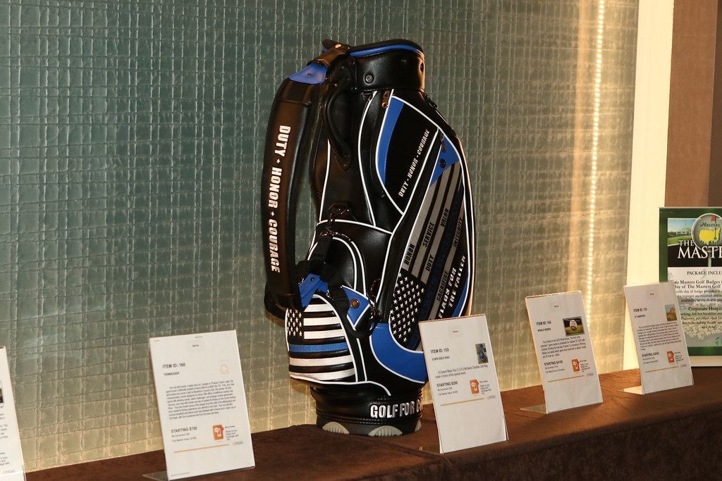 Black, blue, and silver golf bag on display with informational cards.
