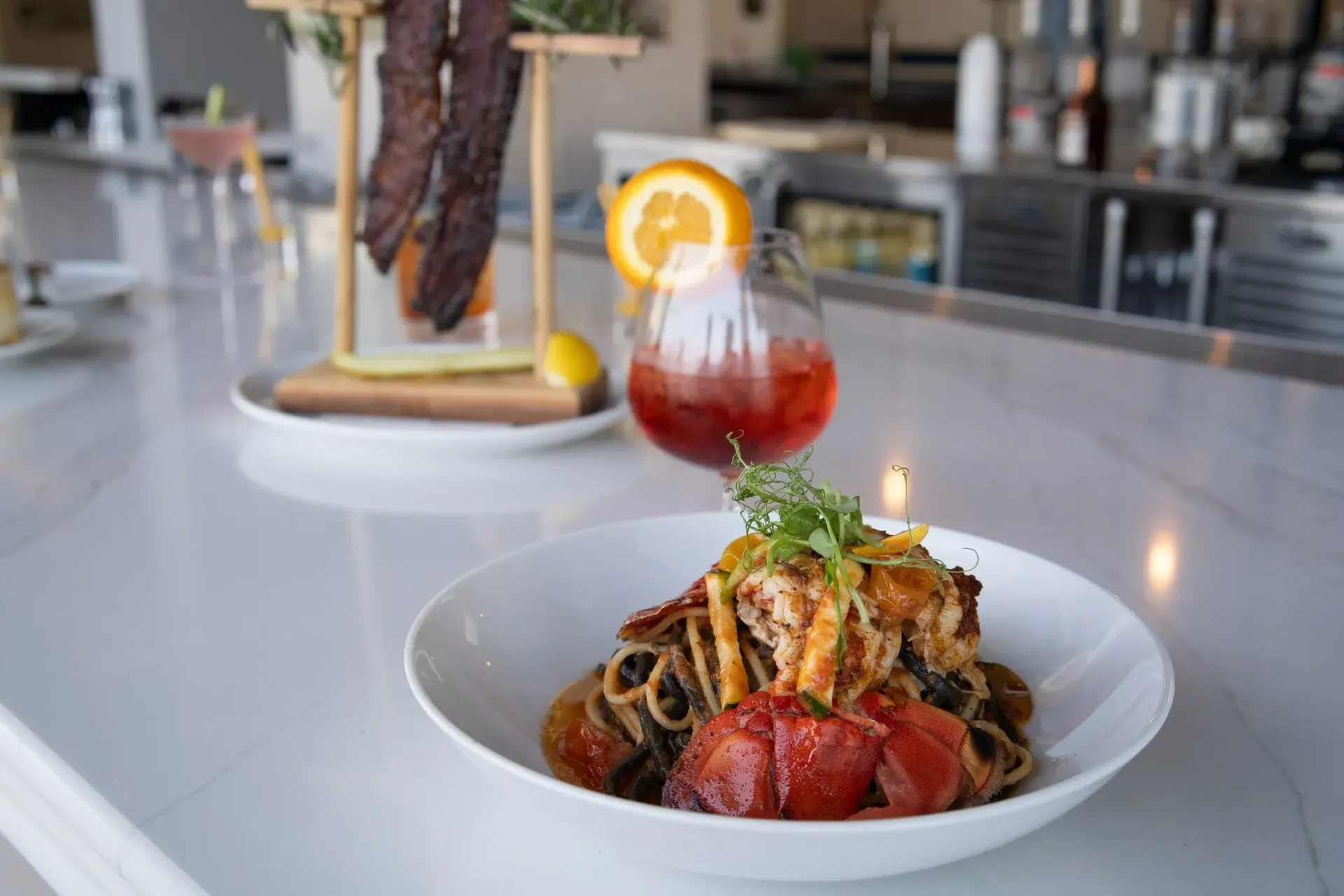 Golfers near carts and golf bags in a sunny, outdoor setting, with a clock tower and palm trees.