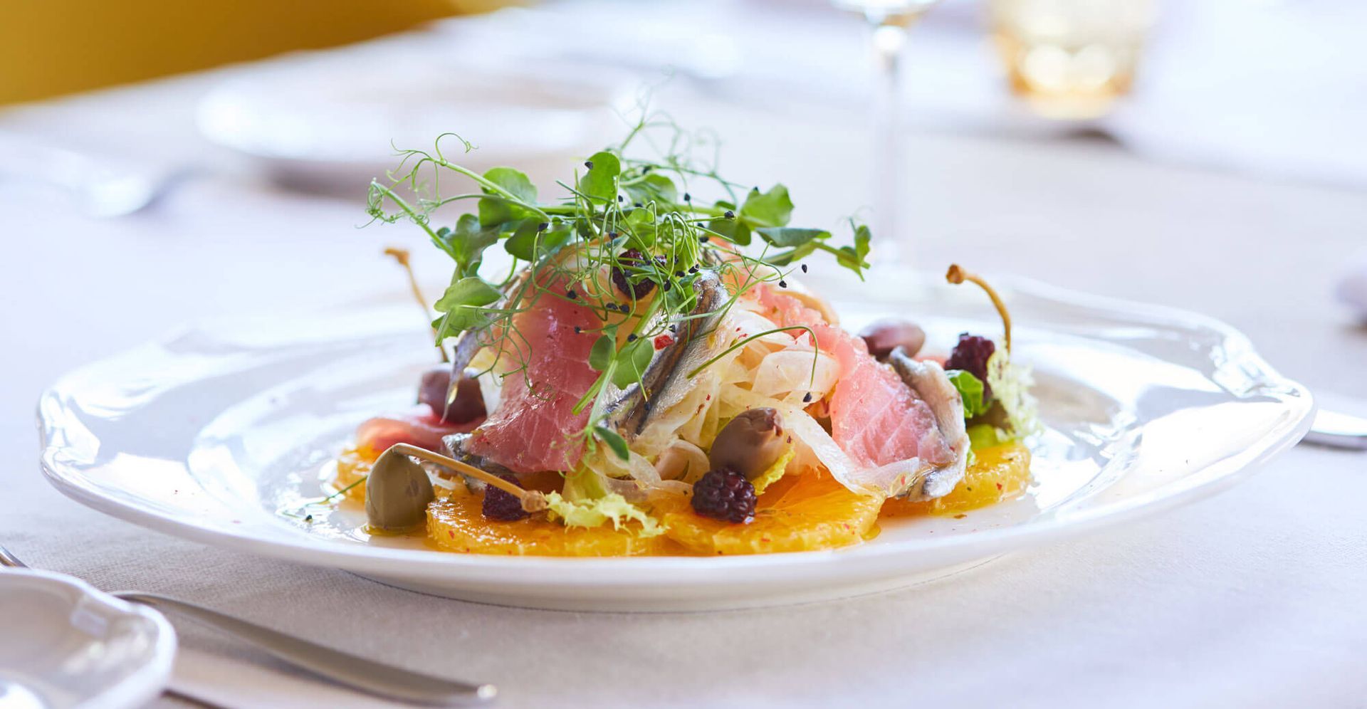 Golfers near carts and golf bags in a sunny, outdoor setting, with a clock tower and palm trees.