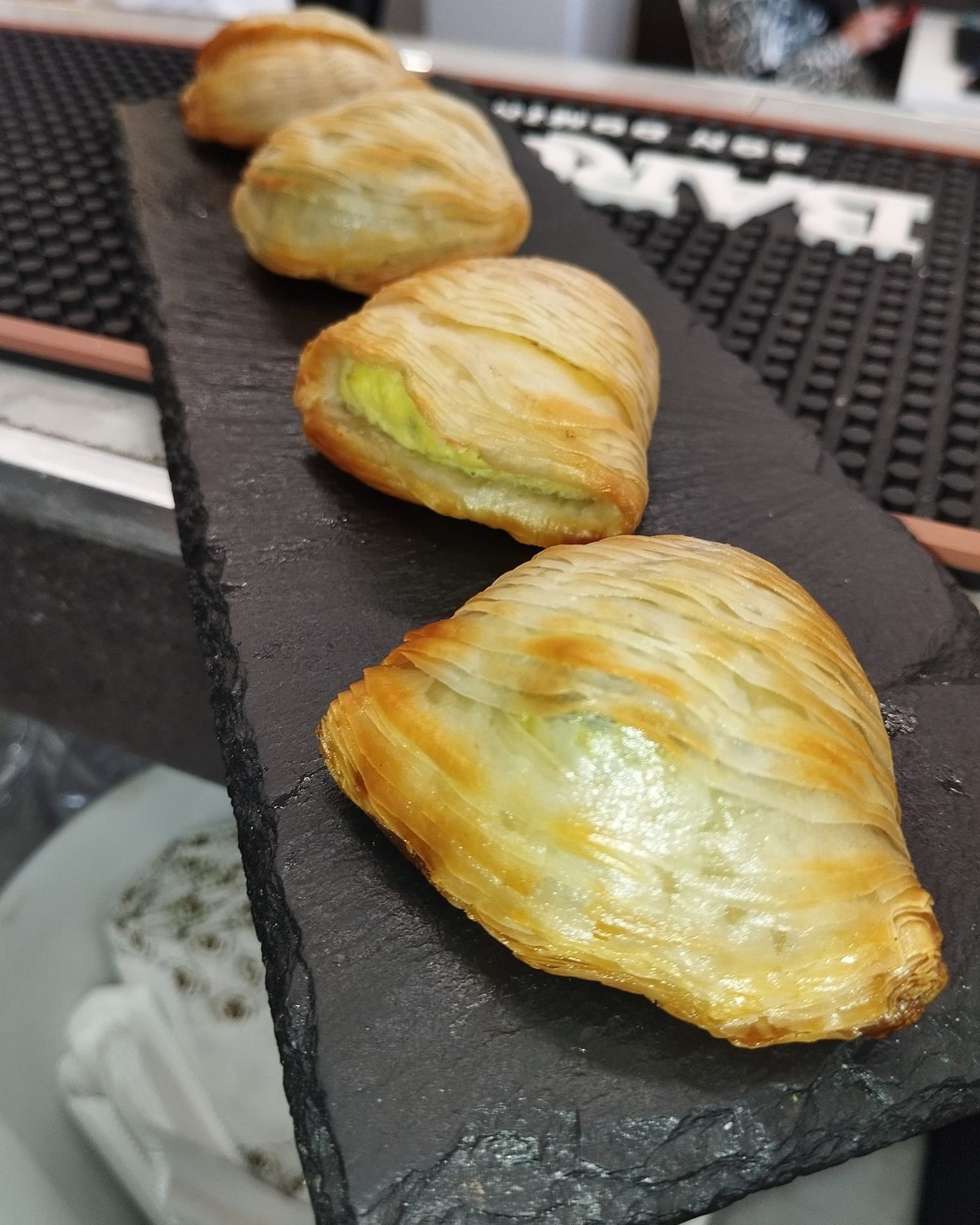 una fila di pasticcini è appoggiata su un vassoio di ardesia.