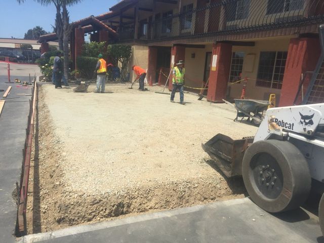 A bobcat is parked in front of a building