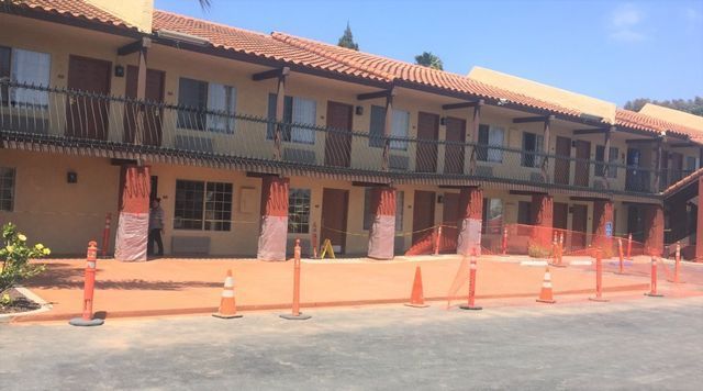 A motel with a lot of orange cones in front of it.