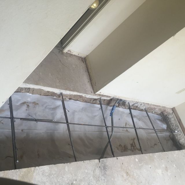 A hole in the floor is being filled with concrete