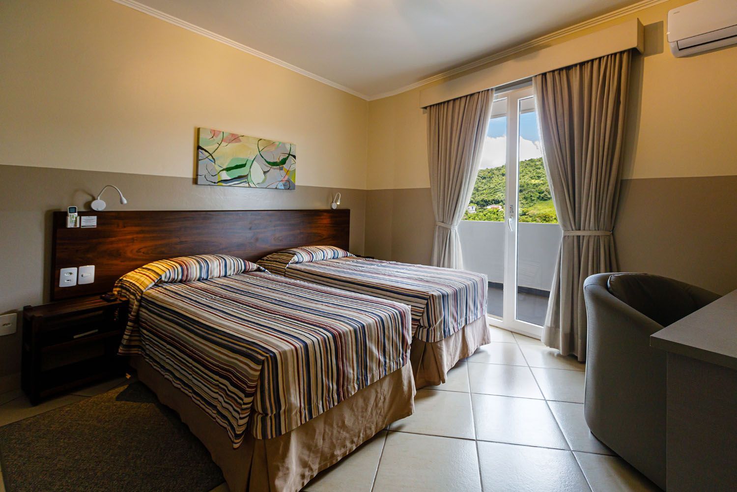 Um quarto de hotel com duas camas e uma cadeira