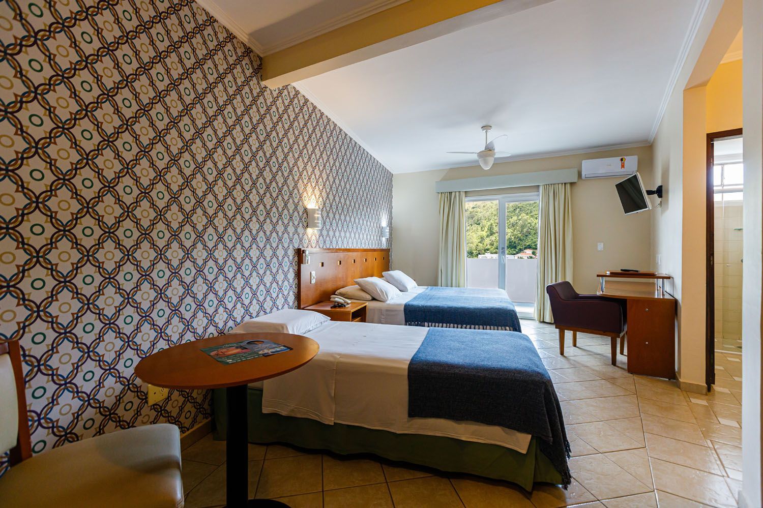 Um quarto de hotel com duas camas e uma mesa.